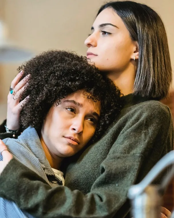 Two women, one supporting the other